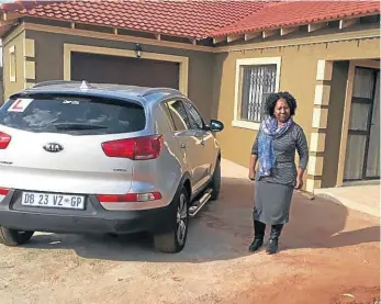  ??  ?? Jeremia Ngwenya’s wife, Sibongile, stands next to the Kia Sportage whose computer box was allegedly ruined at the dealership he had taken it to for repairs.