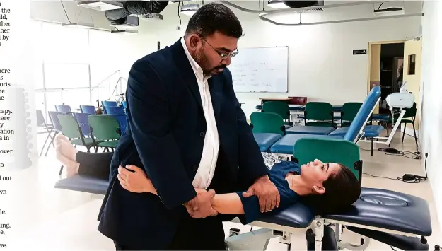  ??  ?? Kumar teaches his physiother­apy students how to work with patients in RSDH College's skills laboratory.