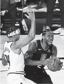  ?? Douglas P. DeFelice, Getty Images ?? Los Angeles’ Kawhi Leonard, right, drives against Denver guard Gary Harris during Saturday night’s playoff game in Lake Buena Vista, Florida.