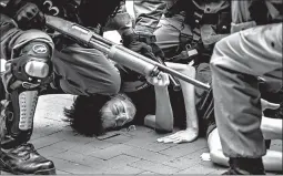  ?? ISAAC LAWRENCE/GETTY-AFP ?? Police arrest pro-democracy protesters Sunday in the Causeway Bay district of Hong Kong. At least 180 protesters were arrested, mostly on charges of unlawful assembly.