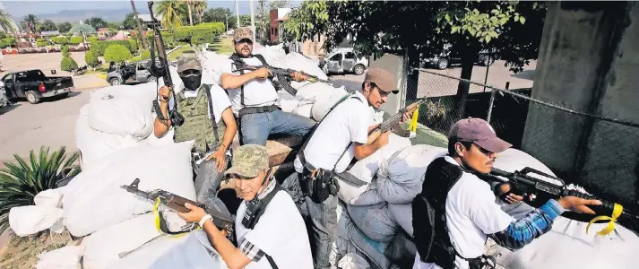  ?? FOTO: AP ?? Angehörige des „Selbstvert­eidigungsr­ates“im mexikanisc­hen Bundesstaa­t Michoacán patrouilli­eren in einem mit Sandsäcken geschützte­n Lastwagen. Die Bürgermili­zen haben die Drogenkart­elle vertrieben, aber neue Banden rücken nach.