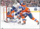  ?? The Canadian Press ?? Edmonton Oilers goaltender Cam Talbot keeps his eye on the puck as teammate Mark Letestu (55) battles with Vancouver Canucks’ Bo Horvat (53) during NHL action in Edmonton on Saturday night.