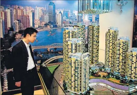  ?? XAVIER CERVERA ?? Junglas de cristal y cemento. Un joven contempla la maqueta de una promoción inmobiliar­ia en la ciudad de Cantón, en el sudeste de China