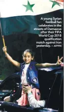  ??  ?? A young Syrian football fan celebrates in the streets of Damascus after their FIFA World Cup 2018 qualificat­ion match against Iran yesterday. –