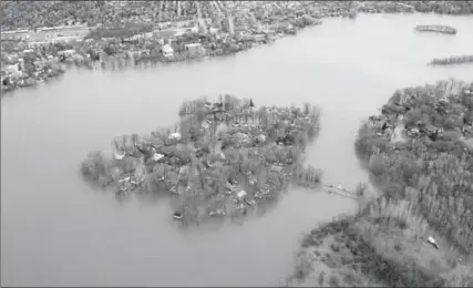  ?? PAUL CHIASSON, THE CANADIAN PRESS ?? Ile Mercier, covered in flood water, is seen on the Riviere des Prairies to the north of Montreal on Monday. The bridge leading to the island is closed.