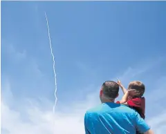  ?? REUTERS ?? A man and a child watch as the ground-based midcourse defence element of the ballistic missile defence system launches in California on Tuesday.