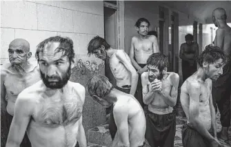  ?? ?? Detained drug users wait to be shaved after arriving at Avicenna Medical Hospital, where about 700 patients undergo withdrawal as part of a 45-day treatment program.