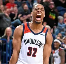  ?? Justin Guido/For the Post-Gazette ?? Duquesne’s Kareem Rozier celebrates a 3-pointer Saturday against George Washington at UPMC Cooper Fieldhouse.