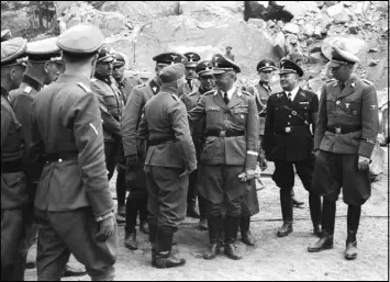  ?? AMICAL DE MAUTHAUSEN VIA THE NEW YORK TIMES ?? Franz Josef Huber, sixth from right at center rear, accompanie­s SS leader Heinrich Himmler, fourth from right, during a visit to the Mauthausen concentrat­ion camp in Austria.