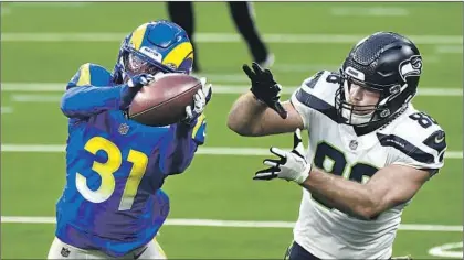  ?? CORNERBACK Wally Skalij Los Angeles Times ?? Darious Williams steps in front of Seahawks tight end Greg Olsen to intercept a pass and seal the Rams’ victory last Sunday. Williams, who earned a full- time starting spot this season, has emerged as one of the defense’s top playmakers.