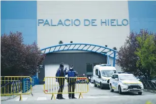  ?? (Juan Medina/Reuters) ?? LOCAL POLICE stand guard outside an ice rink, which will be used as a makeshift morgue, during the coronaviru­s outbreak in Madrid, yesterday.