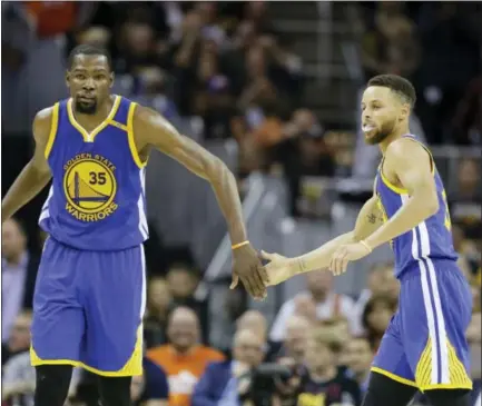  ?? TONY DEJAK — THE ASSOCIATED PRESS ?? Golden State Warriors forward Kevin Durant (35) and Stephen Curry (30) play against the Cleveland Cavaliers during the second half of Game 3 of the NBA Finals in Cleveland Wednesday. The Warriors are one win away from a sweep and their second title in...