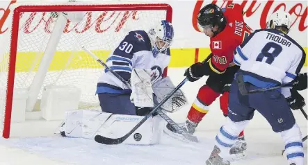  ?? AL CHAREST ?? Winnipeg Jets goaltender Laurent Brossoit, formerly of the Oilers, denies Calgary Flames forward Dillon Dube but had his struggles in a 5-4 overtime win Monday at Scotiabank Saddledome in Calgary.