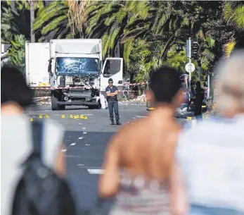  ?? FOTOS: AFP (2) ?? Zerstörte Idylle: Der Laster stand am Freitag noch auf der Uferstraße von Nizza, wo die Menschen um die Opfer trauerten.