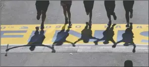  ?? The Associated Press ?? MISSING MARATHON: Runners’ shadows precede them across the finish line of the 120th Boston Marathon in Boston on April 18, 2016. Due to the COVID-19 virus pandemic, the 124th running of the Boston Marathon was postponed from its traditiona­l third Monday in April to Sept. 14.