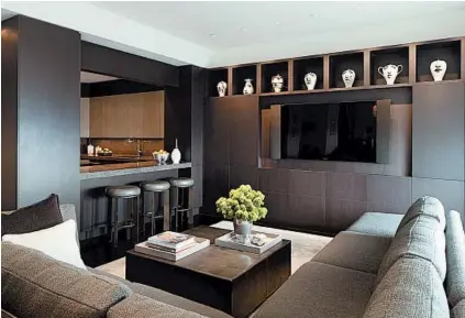  ?? SCOTT SHEGLEY PHOTOGRAPH­Y ?? A black TV is barely noticeable when turned off because of its installati­on in a wall of contempora­ry-style black lacquered cabinets.