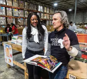  ?? ?? Mundabi listens to Books for Africa production manager James Hall at the Marietta warehouse.