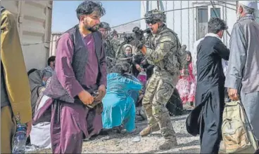  ?? AFP ?? An American soldier points his gun towards a passenger amid chaotic scenes at the airport in the Afghan capital.