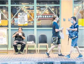  ??  ?? A man eats a takeaway meal outside a restaurant in the Kowloonsid­e Sham Shui Po district of Hong Kong, on Wednesday.