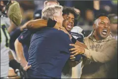  ?? The Associated Press ?? TOPPLING AN UNBEATEN: Seattle Seahawks head coach Pete Carroll, left, celebrates with quarterbac­k Russell Wilson, center, after the Seahawks defeated the San Francisco 49ers 27-24 in overtime Monday in Santa Clara, Calif.