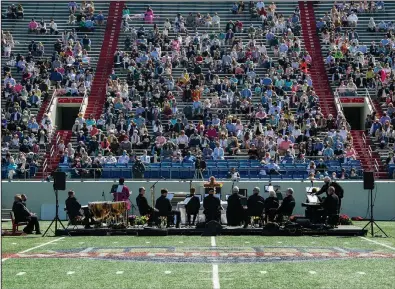  ?? (Arkansas Democrat-Gazette/Stephen Swofford) ?? Congregant­s listen to a sermon Sunday by the Rev. John Robbins, senior pastor at Pulaski Heights United Methodist Church, during an Easter service at War Memorial Stadium in Little Rock. Pulaski Heights canceled its Easter service last year, and decided to hold this year’s service at the stadium in order to accommodat­e social distancing. See more photos at arkansason­line.com/45easter/.