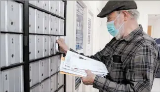  ?? ROBERT F. BUKATY/AP ?? Vaino Kola picks up his mail at the Deer Isle, Maine, post office, which is also a popular meeting place.