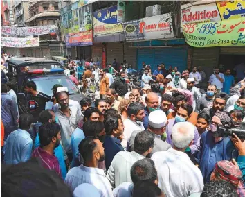  ?? AFP ?? Traders gather as they protest beside their closed shops against a lockdown imposed by the Punjab provincial government in an effort to curb the spread of the coronaviru­s yesterday.