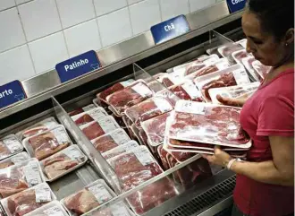  ?? Yasuyoshi Chiba - 17.mar.2017/AFP ?? Consumidor­a escolhe carne em mercado no Rio; produto nacional foi barrado nos EUA