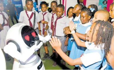  ?? PHOTOGRAPH­ER IAN ALLEN. ?? Students from Jessie Ripoll Primary School and Tomlinson Christian Academy interact with a robot during the Forum for Innovation­s in Teaching at the National Arena in Kingston on Friday, January 26.