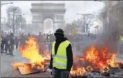  ?? AP ?? A protester stand in front of a barricade on fire during a yellow vests demonstrat­ion in Paris.