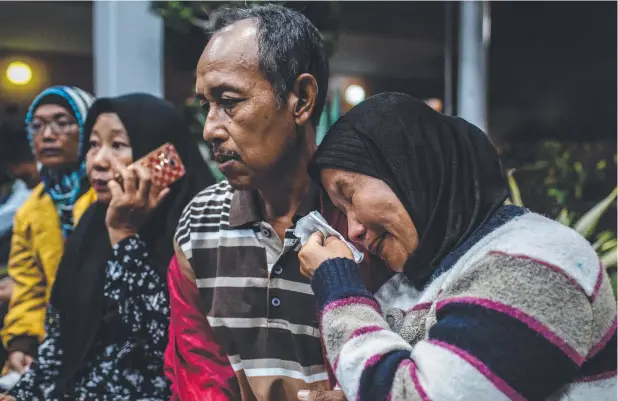  ?? Pictures: GETTY IMAGES ?? TRAGEDY: A woman whose daughter, son-in-law, and two grandchild­ren were on the Lion Air flight waits for news at a crisis centre in Jakarta.