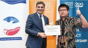  ?? ?? Bright future: Prof mushtak (left) presenting the Global citizenshi­p Scholarshi­p to david adriel Ongkowidja­ja.