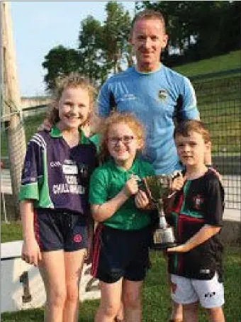  ??  ?? The winners of the Killavulle­n Family Relay 2018 The Hanrahan Familly Killavulle­n, Dad Niall with his daughters Ava and Mia being presented with the Norma Walsh Cup by Norma’s grandson Will Thornhill