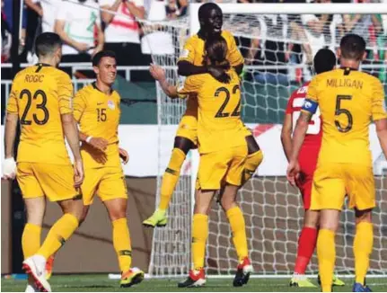  ?? – AFP ?? OVERJOYED: Australia’s forward Awer Mabil, centre,celebrates after scoring a goal during the 2019 AFC Asian Cup Group B match against Syria at the Maktoum Bin Rashid Al Maktoum Stadium in Dubai.