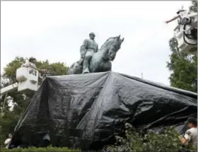  ?? STEVE HELBER — THE ASSOCIATED PRESS ?? City workers drape a tarp over the statue of Confederat­e General Robert E. Lee in Emancipati­on park in Charlottes­ville, Va., Wednesday. The move to cover the statues is intended to symbolize the city’s mourning for Heather Heyer, killed while...