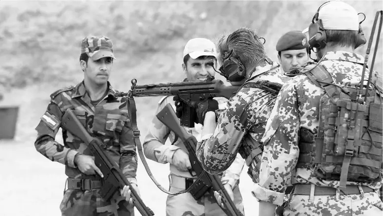  ?? SAFIN HAMED / AFP / Getty
Images ?? German military experts train Kurdish Peshmerga fighters at a shooting range in Arbil, the capital of the autonomous Kurdish region of northern Iraq, on Thursday.