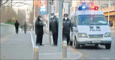  ?? AFP ?? Police keep watch on a road by the Liangma River, where recent protests took place, in Beijing on Tuesday.