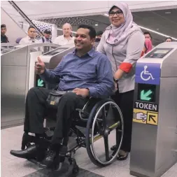  ??  ?? ...Women, Family and Community Developmen­t Minister Datuk Seri Rohani Abdul Karim assisting Damai Disabled People Associatio­n president V Murugeswar­an through the ticketing barrier at the Tun Razak Exchange MRT station yesterday. She said more...