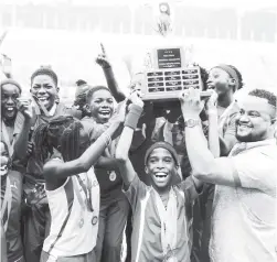  ?? GLADSTONE TAYLOR/PHOTOGRAPH­ER ?? Group CEO at Tastee Ryan Foster (right) presents the championsh­ip trophy to members of the Hydel Prep School team after their 2017 JISA Tastee National Prep Schools Track and Field Championsh­ips win at the National Stadium yesterday.