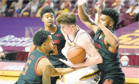  ?? JIM MONE/AP ?? Maryland’s Eric Ayala (5) and a teammate double-team Minnesota’s Liam Robbins in the first half Saturday in Minneapoli­s.