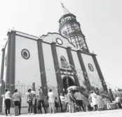  ??  ?? > Afuera de la iglesia se llevó a cabo el baño de San Juan Bautista.