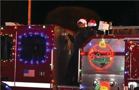  ?? (Pine Bluff Commercial/I.C. Murrell) ?? Engineers with the Pine Bluff Fire Department wave to the crowd during the city’s Christmas parade Thursday as it heads down Main Street.