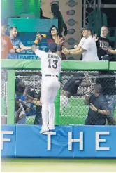  ?? WILFREDO LEE/AP ?? Marlins left fielder Marcell Ozuna can’t leap high enough to bring back Travis d'Arnaud’s seventh inning homer.