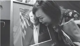  ?? NHAC NGUYEN / AFP / GETTY IMAGES ?? Mai Tran, an American of Vietnamese descent, grieves over a portrait of John Mccain during a memorial tribute at the US Embassy in Hanoi on Monday.