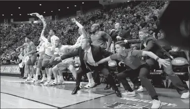  ?? AP/GREGORY BULL ?? Members of the Marshall Thundering Herd celebrate their 81-75 victory over Wichita State in the first round of the NCAA Tournament. While the tournament has given fans a lot of upsets with teams like Maryland-Baltimore County, Loyola-Chicago and...