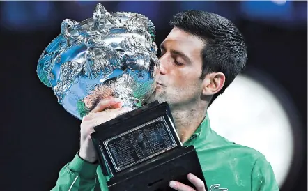  ??  ?? Serbia’s Novak Djokovic kisses the Norman
Brooks Challenge Cup trophy after his victory against Austria’s Dominic Thiem in their men’s singles final on day 14 of the Australian Open tennis tournament in Melbourne yesterday. — AFP