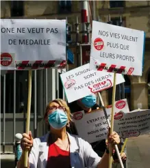  ??  ?? Fronde. Des soignants manifesten­t devant l’hôpital Tenon, à Paris, le 20 mai, réclamant une autre reconnaiss­ance que des médailles.