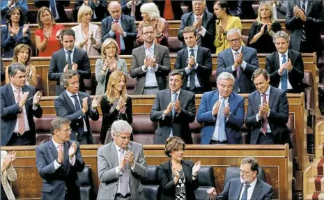  ?? Paul White/Associated Press ?? Prime Minister Mariano Rajoy, bottom right, is applauded Wednesday by party members after his speech at the Spanish parliament in Madrid, Spain. Mr. Rajoy said he rejected offers of mediation in the Catalonia crisis, and called for respect of Spanish...