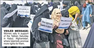  ??  ?? VEILED MESSAGE: Women rally in support of the Taliban Saturday in Kabul, Afghanista­n, where Islamists promise more rights for them.