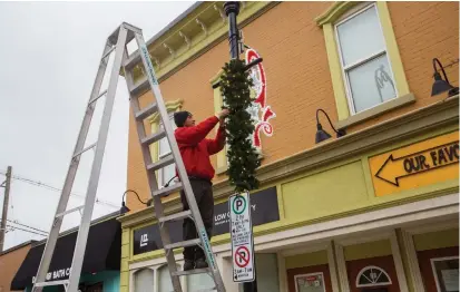  ?? JULIE JOCSAK TORSTAR ?? Joe Blackborow, a wildlife technician with Skedaddle Humane Wildlife Control, puts up the Christmas decoration­s on Front Street in Thorold on Wednesday. Every year Skedaddle takes a break from chasing local wildlife to help decorate the town for Christmas.